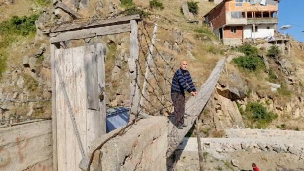 İki dağ arasındaki evine kapılı asma köprüyle ulaşıyor